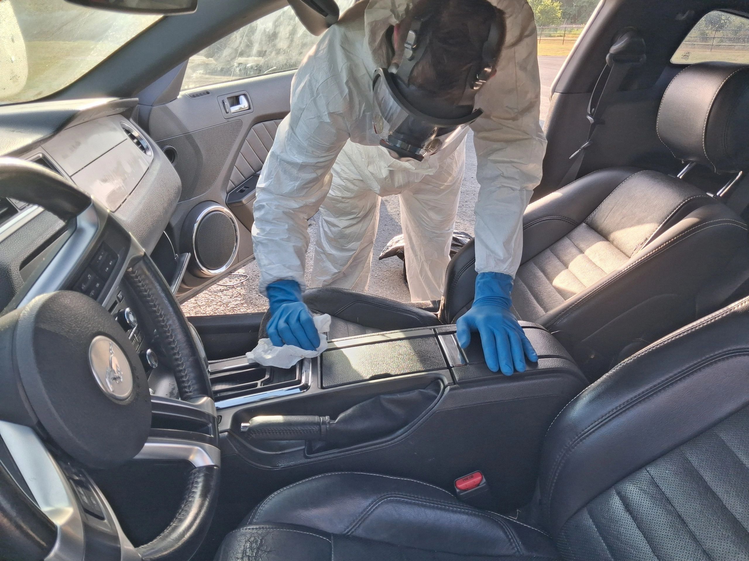 Man in Tyvek, cleaning up Blood out of Vehicle